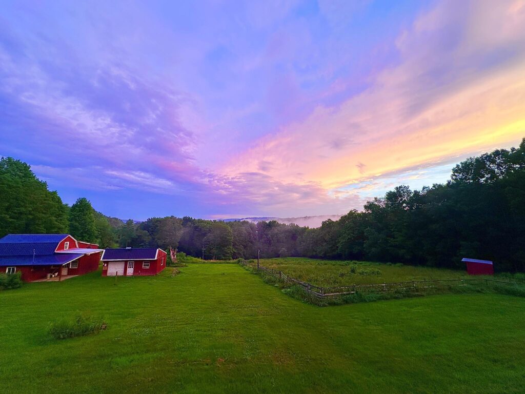 picture of a red barn and sky at sunset